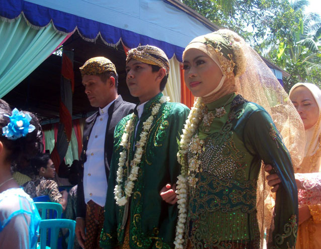 A young javanese couple wearing traditional clothes for their public wedding